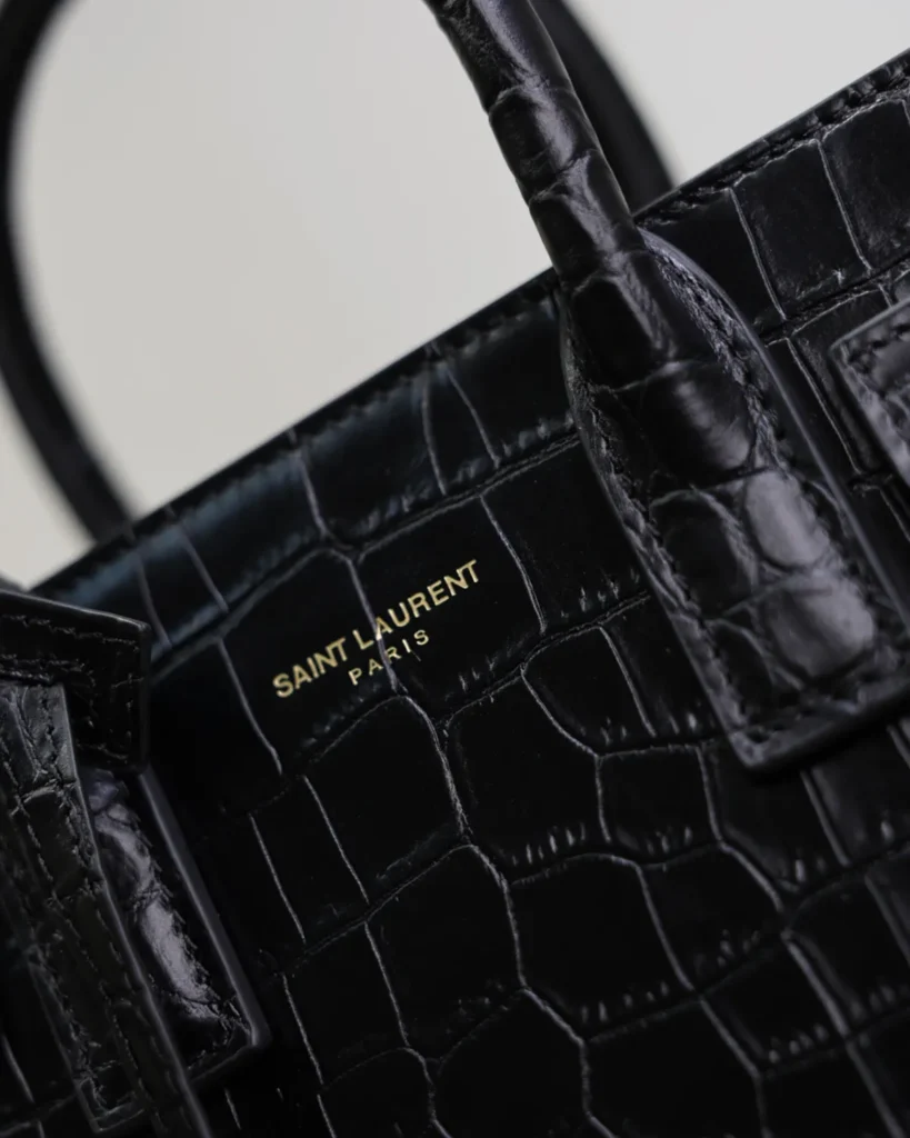 Black Embossed Accordion Tote — handle detail view