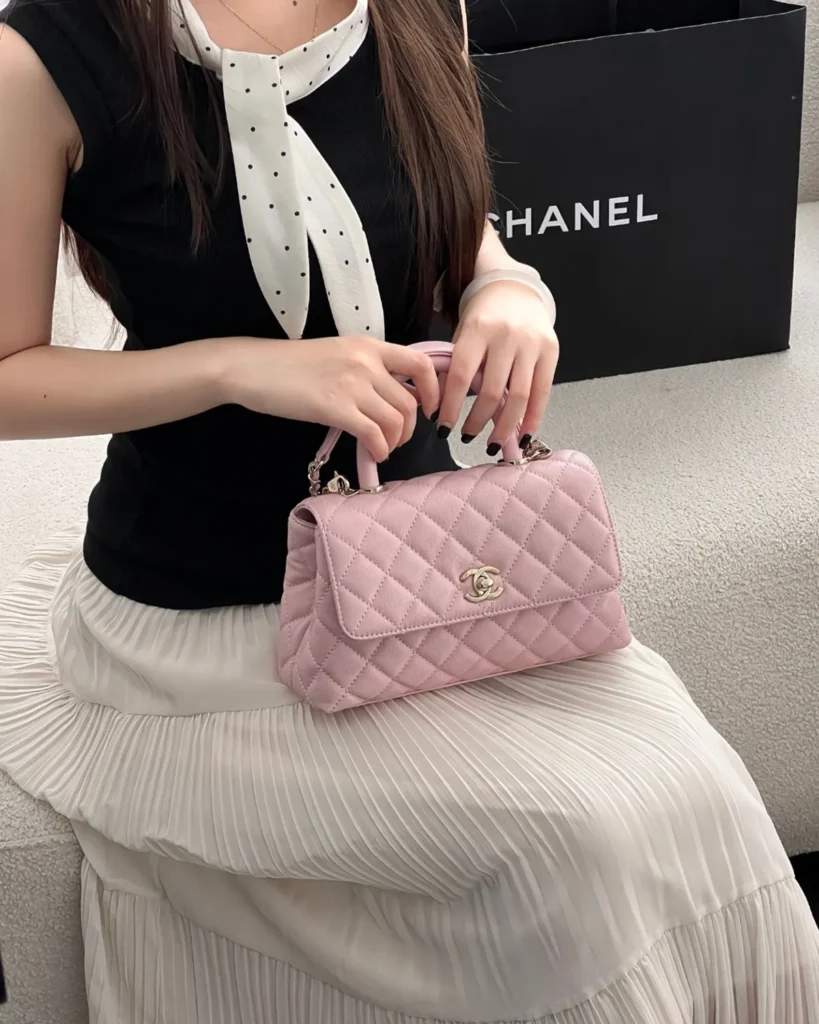 Light Pink Quilted Top-Handle Flap Bag — carried seated view
