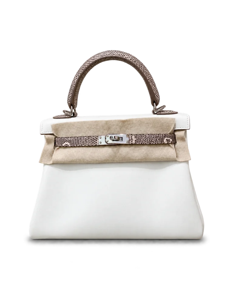 Upright front view of a white top-handle bag with a taupe scale-pattern handle and closure strap and protective felt